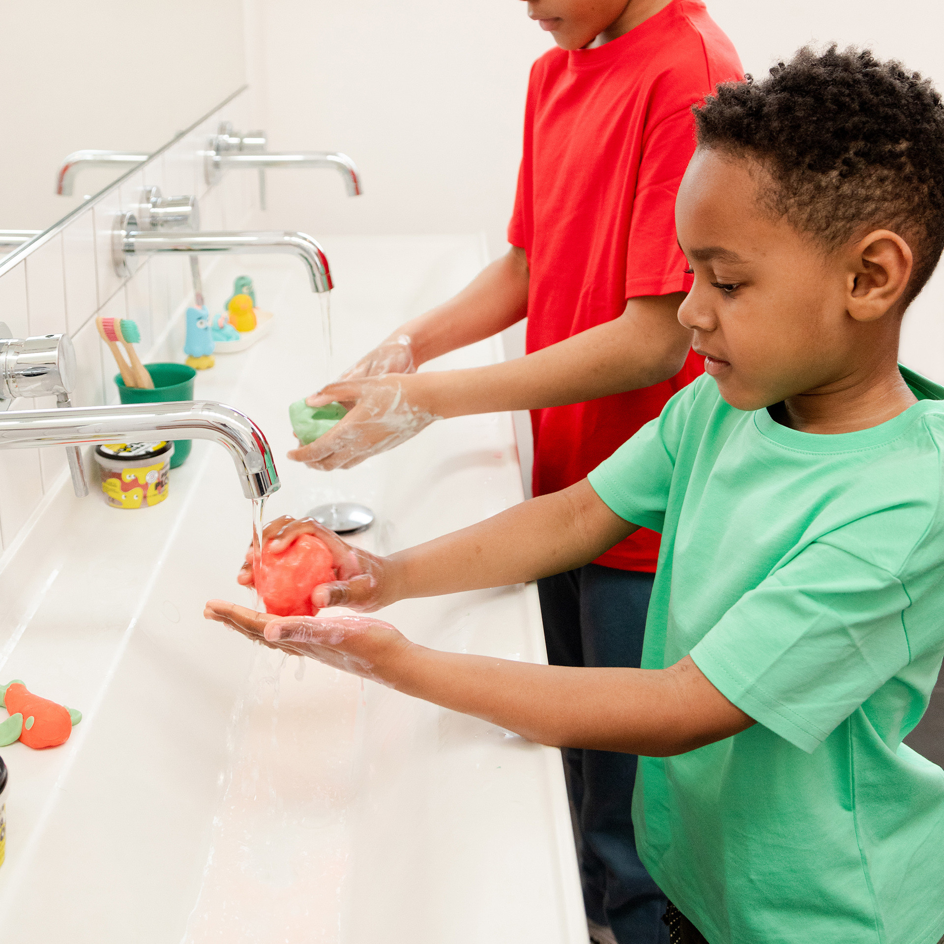 Enfants se lavant les mains avec la pâte à modeler lavante rouge Pataploof