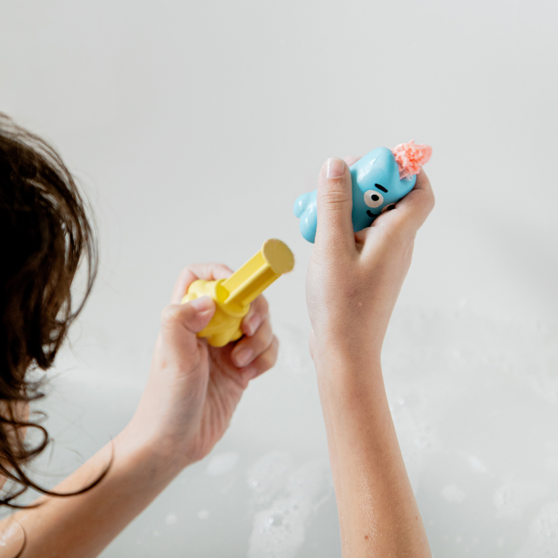 Enfant dans le bain avec un jouet de bain Ploofy et de la pâte à modeler lavante